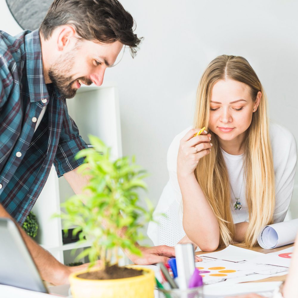 two-young-businesspeople-analyzing-graph